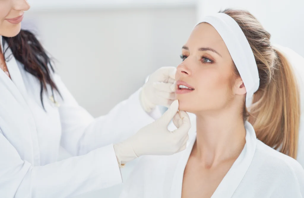 A professional dermatologist examining a woman's skin during a laser treatments consultation.