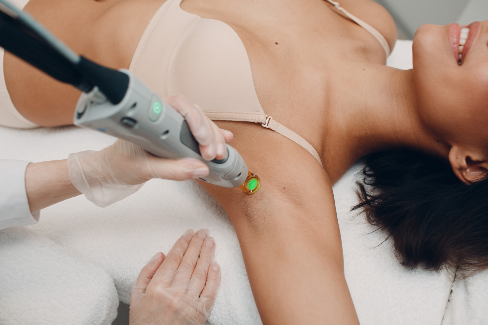 A woman receiving laser hair removal treatment on her underarm.